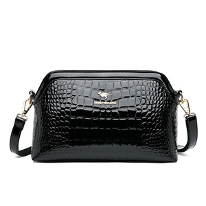 Glossy black crocodile pattern shoulder bag with golden kangaroo logo on white background