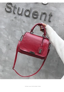 Gros plan d'un sac à main vintage rouge en cuir PU avec détails métalliques et anse