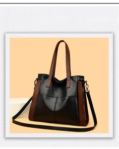 Détail d'un grand sac cabas avec coutures en V et poignées marron contrastées