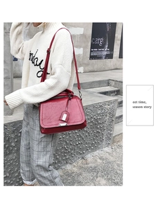Détails du sac à main en cuir rouge foncé avec fermoir argenté et breloques de style