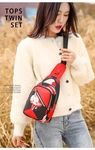 Detail of red and black chest bag with cartoon illustration on a female model outdoors