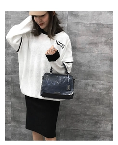 Vue détaillée d'un sac à main rétro bleu foncé en cuir avec texture cirée et chaîne