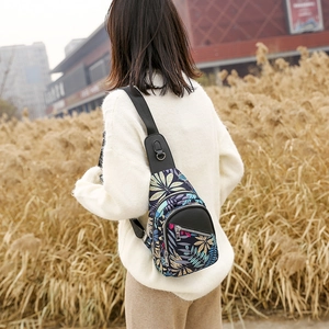 Outdoor shot of a multi-zippered chest bag with vibrant tropical floral prints on oxford cloth
