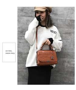 Gros plan du sac à main en cuir marron avec boucle métallique et rivets sur un mannequin