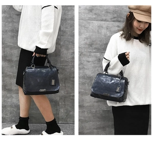 Détail du sac à bandoulière en cuir bleu vintage avec rivets métalliques et sangle