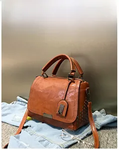 Vue détaillée d'un sac à main marron en similicuir avec clous et bandoulière réglable