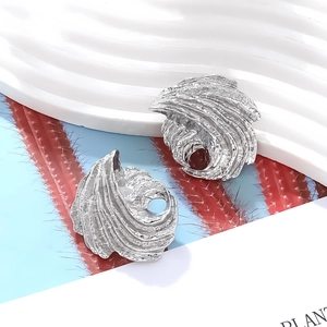 Irregular silver leaf earrings with spiral lava texture and hammered metallic finish