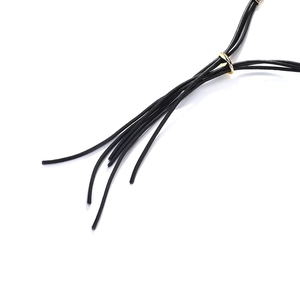 Detailed close-up of multiple black cord strands with a polished gold metal slide buckle
