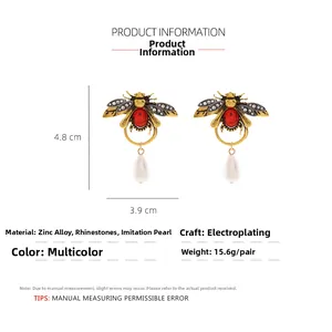 Vue détaillée des boucles d'oreilles abeille vintage avec strass colorés et perles