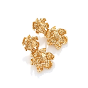 Close-up of golden double-layered floral earrings with textured metallic finish on white back