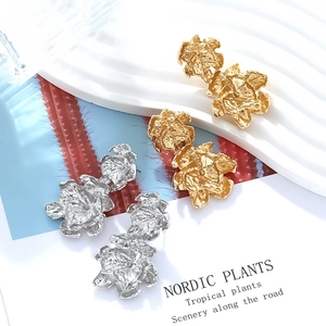Close-up of luxury double-layer alloy floral drop earrings in gold and silver finish