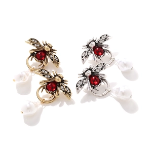 Gros plan de boucles d'oreilles abeille vintage avec cristaux et perles pendantes