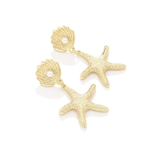 Dettaglio di orecchini a stella marina dorati con conchiglie e perle per stile spiaggia