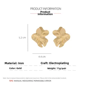 Vue détaillée de grandes boucles d'oreilles feuilles dorées avec texture ondulée chic