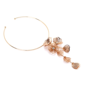 Detailansicht eines goldenen Metall-Chokers mit hohlen Blüten und Kristallzentrum