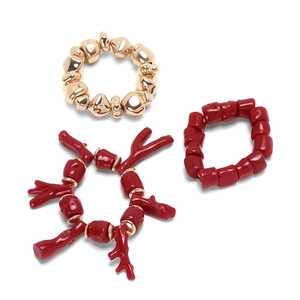 Three-piece gold beaded and red resin coral bracelet set with vacation style charms