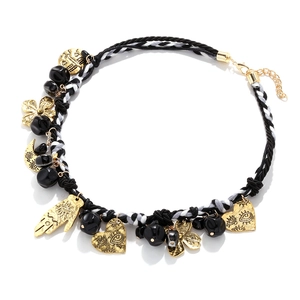 Detail of hand-woven rope necklace with golden Hamsa Hand, crescent moon and heart charms