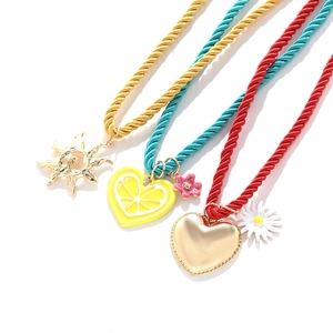 Detailed macro view of colorful nautical rope necklaces with gold heart and flower charms