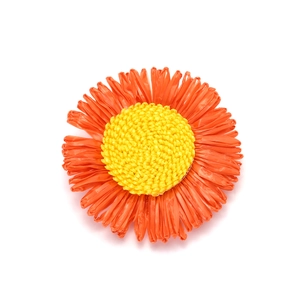 Handmade woven orange sunflower hair clip with yellow center on white background