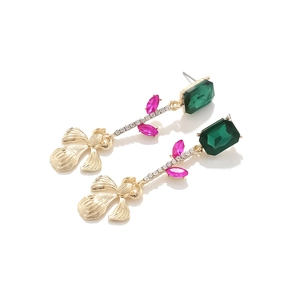 Détail de boucles d'oreilles fleurs avec pierres taille émeraude vertes et roses