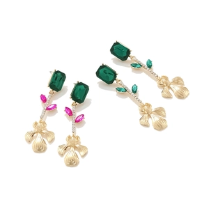 Vue détaillée de longues boucles d'oreilles iris dorées avec cristaux colorés
