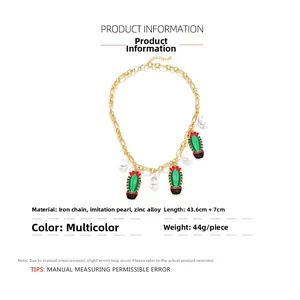Detailed view of colorful cactus charms and faux pearls on a gold-plated link necklace