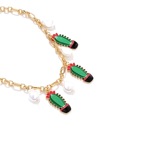 Golden chain necklace with green enamel cactus pendants and baroque pearls on white background