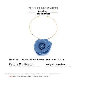 Gros plan du collier choker fleur en denim avec anneau doré et camélia en tissu bleu