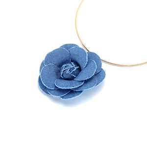 Détail d'une fleur en denim bleu faite main avec bords effilochés sur anneau doré