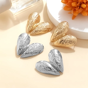 Detail of metallic seashell earrings in gold and silver finish with realistic texture