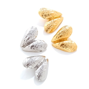 Close-up of vintage shell earrings in gold and silver finish with detailed ocean textures