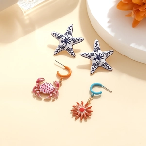 Set di quattro orecchini con motivi dipinti di stelle marine, granchio e sole