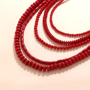 Bohemian multilayered vibrant red bead necklace set featuring varied bead shapes