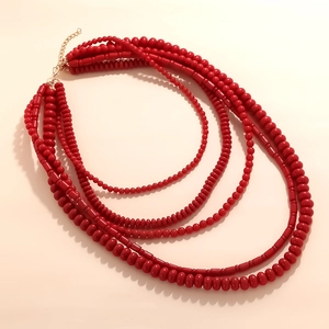 Macro detail of multi-layered red beaded necklace with golden adjustable chain link