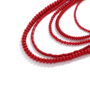 Close-up of bohemian multi-layer red beaded necklace featuring glossy round and tube beads