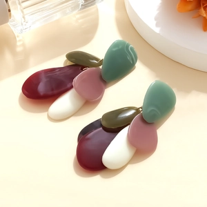 Vue macro de boucles d'oreilles pendantes avec galets géométriques en résine colorée