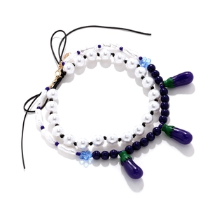 Close-up of handmade pearl necklace with cute purple eggplant pendants and blue beads