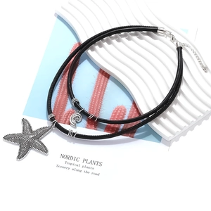 Double-layered black cord necklace with textured starfish and shell charms for beach style