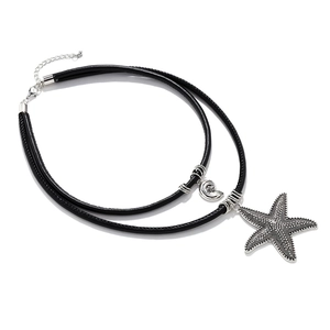 Detail of silver starfish pendant on double-layer black cord with spiral shell charm