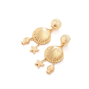 Boucles d'oreilles pendantes dorées avec coquillages et étoiles de mer sur fond blanc