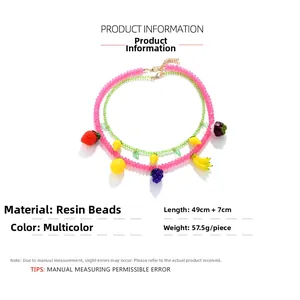 Dettaglio della collana di perline colorate con ciondoli a forma di limone e fragola