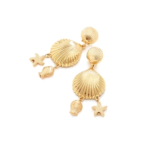 Détail de boucles d'oreilles coquillage dorées avec pendentifs étoile et poisson