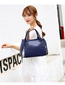 Détail d'un sac à main bleu marine en cuir grainé avec empiècements à motif serpent