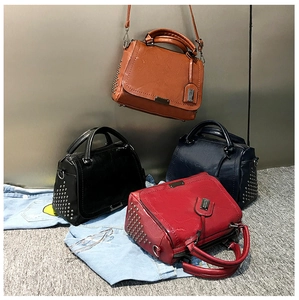 Détail de quatre sacs à main colorés avec clous métalliques et finition cuir PU brillant