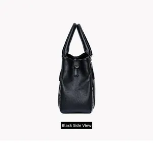 Détail du sac à main noir en cuir grainé montrant la texture latérale et les poignées rondes