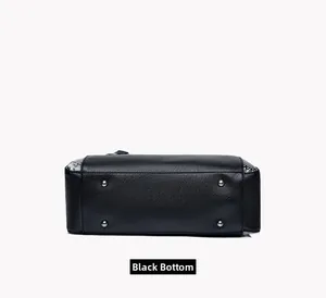 Vue détaillée du fond de sac noir en cuir grainé avec quatre pieds de protection argentés