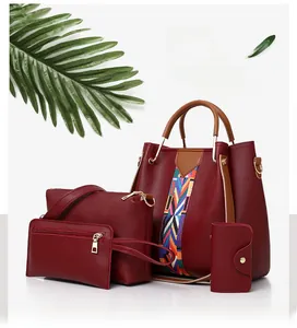 Macro detail of burgundy four-piece bag set with tote, pouch, wallet and key holder