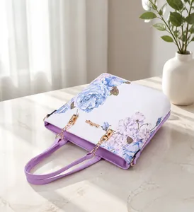 Detail of white leather handbag featuring purple trim and elegant floral patterns