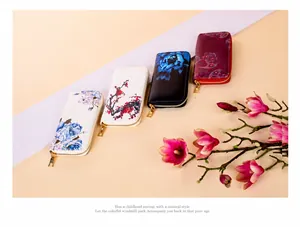 Detail of four floral print long zip wallets with gold-toned metal zippers on a floral backdrop