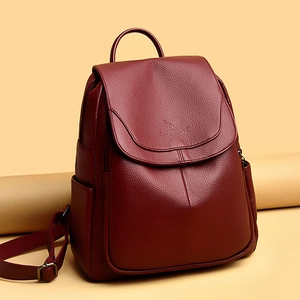 Detail of burgundy pebbled leather backpack showing kangaroo embossed logo on the flap